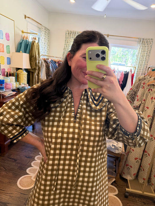 Model taking a close mirror photo in the Painted Gingham Quinn Mini, showing the olive gingham and collar