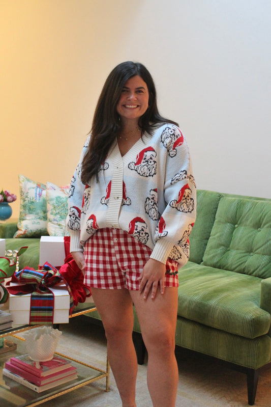 Model wearing the Merry PJ Shorts, red and white gingham, with a Santa print cardigan