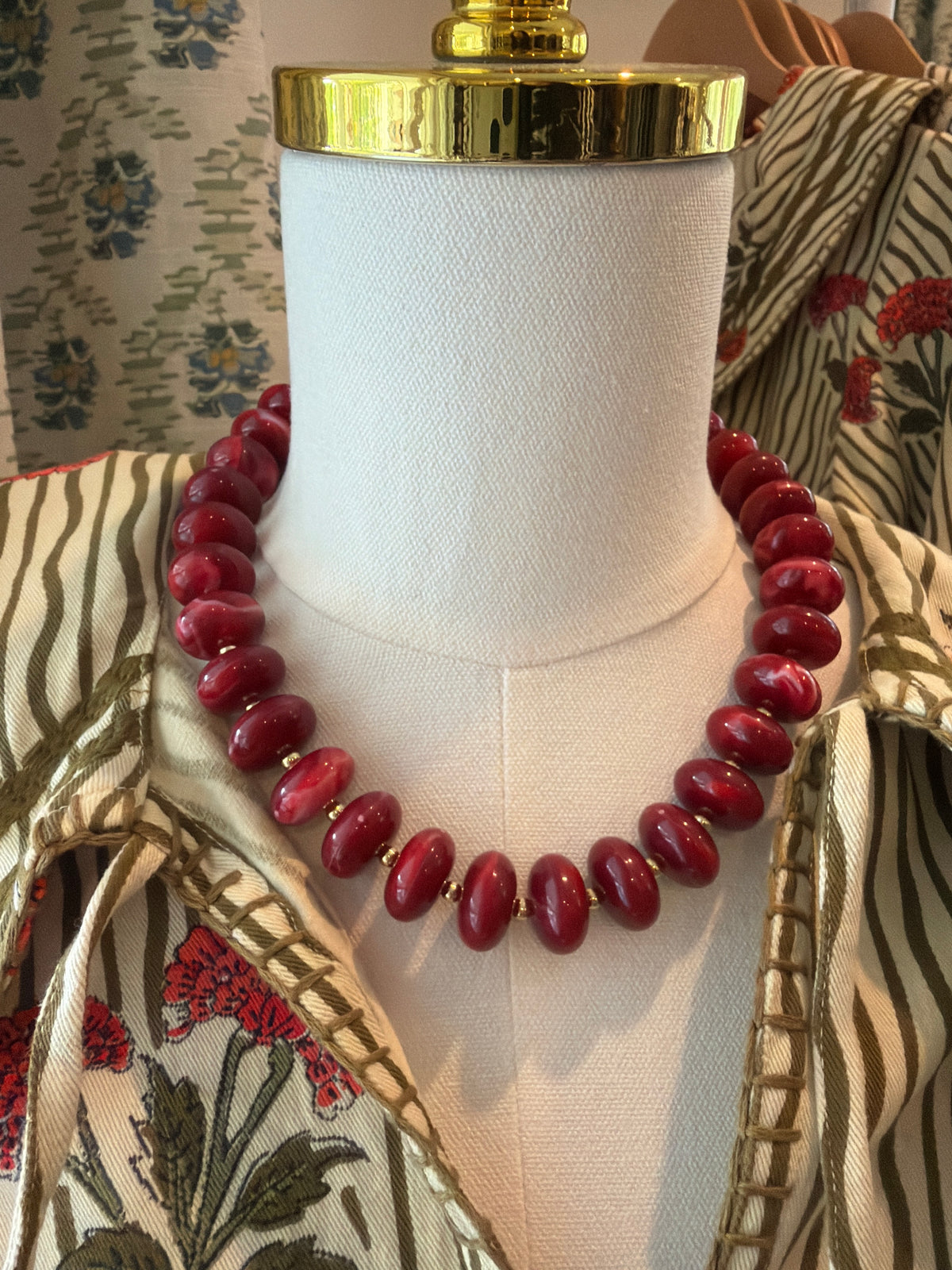 Maroon Bubble Necklace with maroon round beads, shown on a dress form