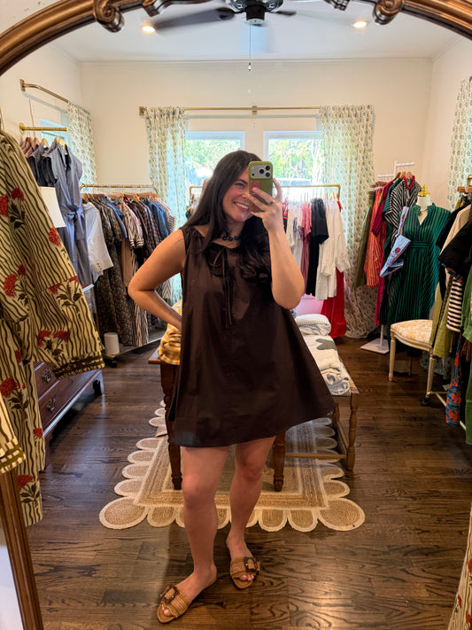 Model taking a mirror photo in the Brown Cotton Mini, a sleeveless brown dress, full length