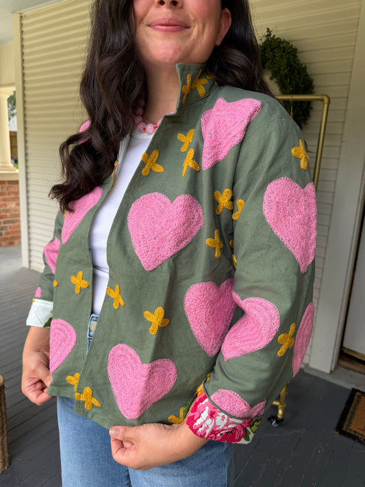 Close view of the Green Canvas Heart Jacket's pink embroidered hearts and yellow crosses