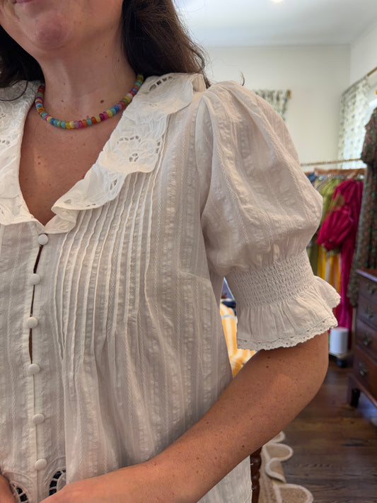 Close view of the White Floral Eyelet Top's eyelet collar, pintucks and puff sleeve