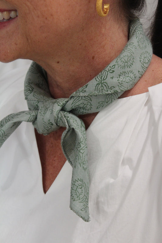 Sage green Linen Bandana with a block print, tied at a model's neck