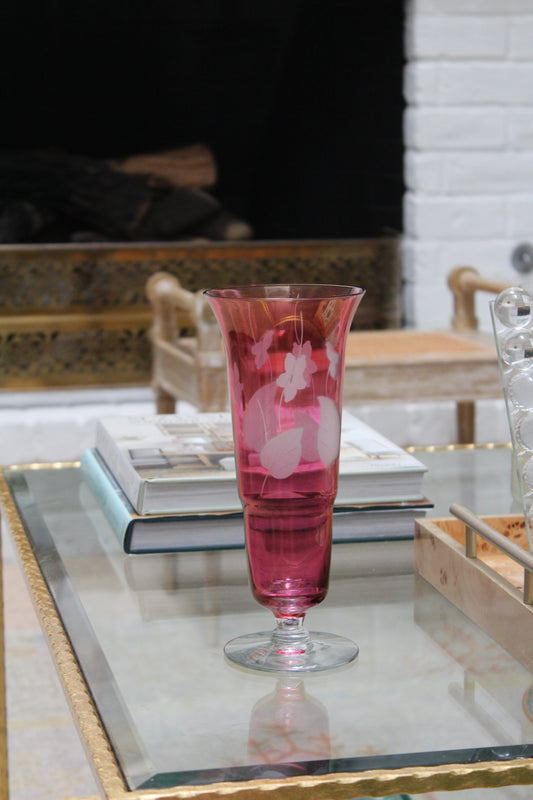 Cranberry Glass Vase styled on a glass coffee table next to a stack of books