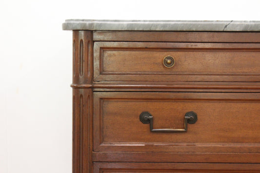 Close view of the vintage Louis chest's wood drawers and brass bail pulls