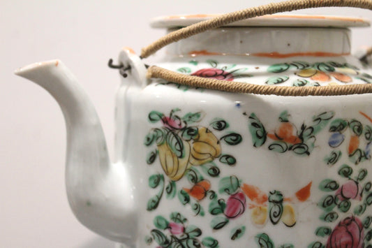 Close view of the famille rose teapot's spout, floral pattern and woven handle