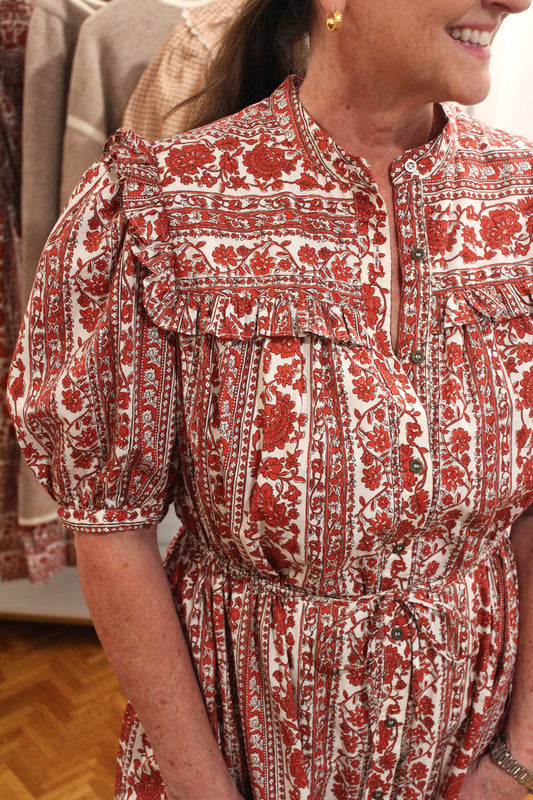 Close view of the Molly Dress's red and white floral print, ruffle yoke and puff sleeves