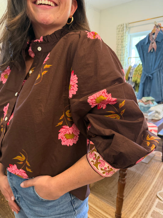 Close view of the Dahlia Blouse's pink dahlia print on brown and ruffle collar