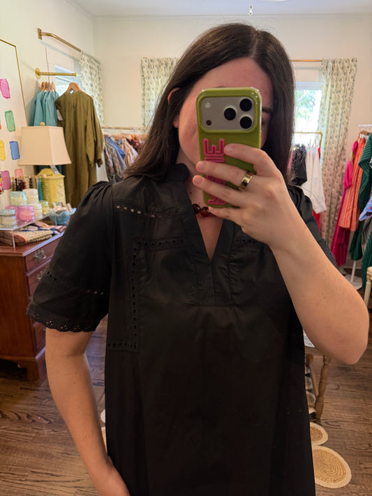 Model taking a close mirror photo in the Black Shift Mini, showing the black cotton and short sleeves