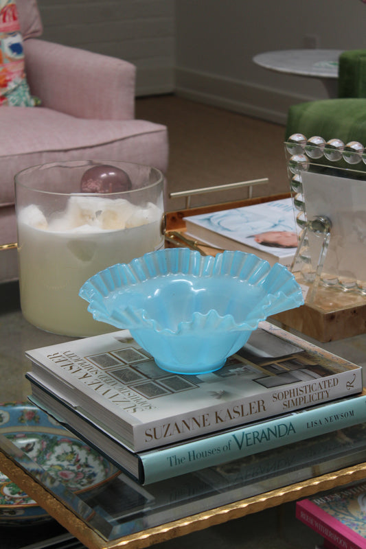 Light Blue Fenton Bowl styled on a stack of books on a coffee table