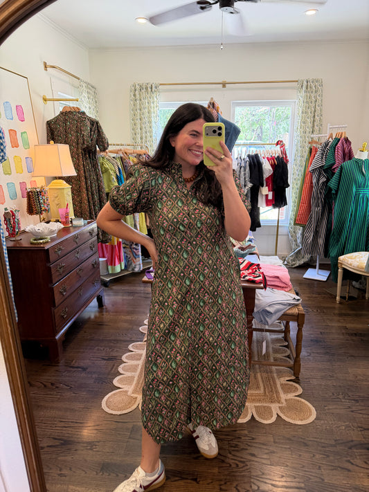Model taking a mirror photo in the Forrest Midi, a green and brown print midi, full length