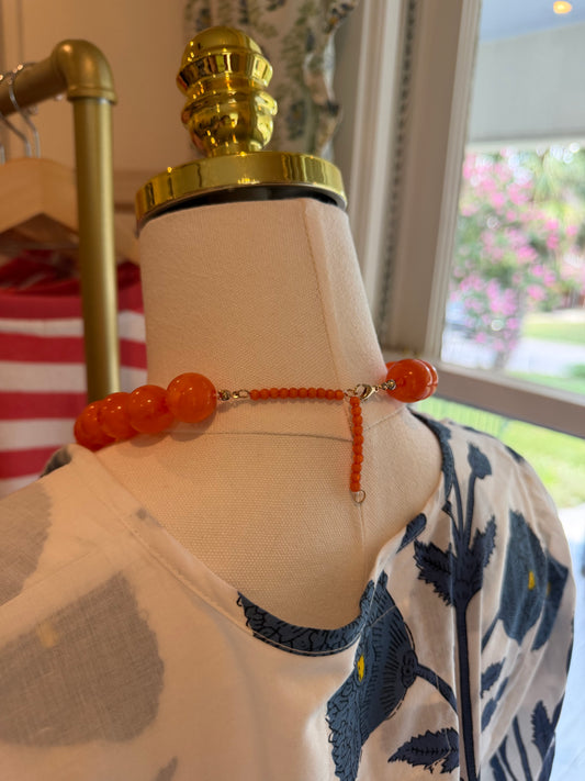 Back view of the Orange Ball Necklace on a dress form, showing the gold chain
