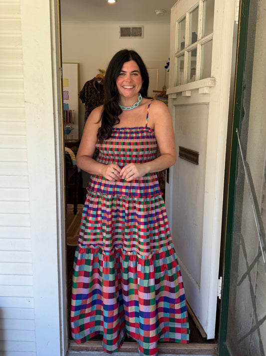 Model wearing the Jewel Maxi Dress, a multicolor plaid tiered maxi with thin straps