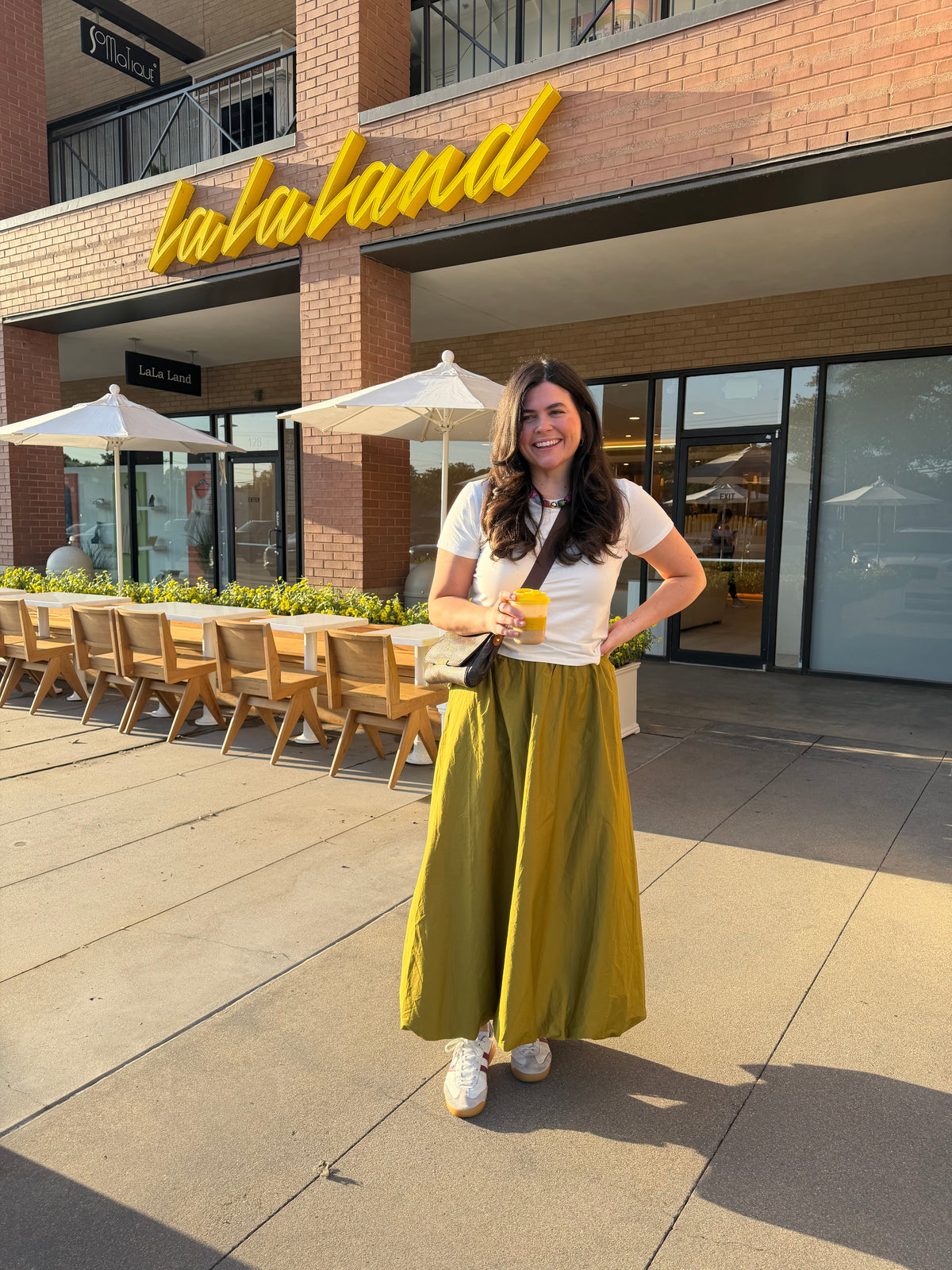 Model wearing the Olive Bubble Skirt, an olive green maxi skirt, outdoors with a white tee