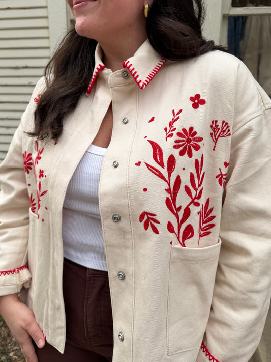 Close view of the Jamie Jacket's red floral embroidery and stitched collar on ivory denim