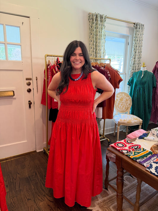 Model wearing the Cayenne Midi, a red sleeveless smocked midi, full length in the shop