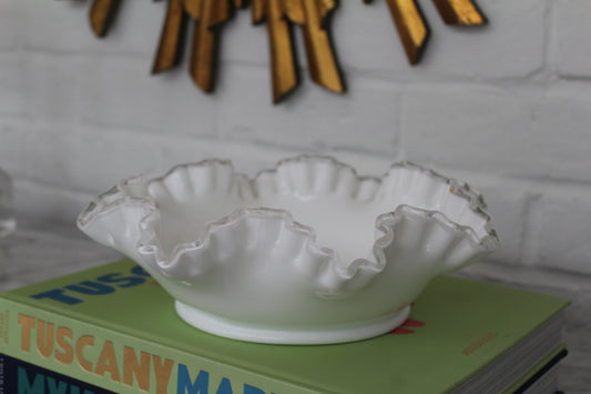 Large White Fenton Bowl with a ruffled rim resting on a stack of books