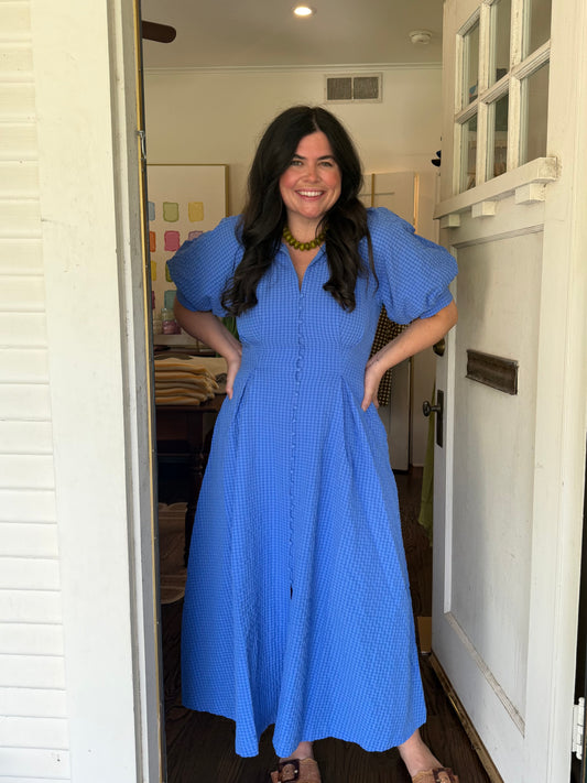 Model wearing the French Blue Midi Dress, hands on hips, full length in a doorway
