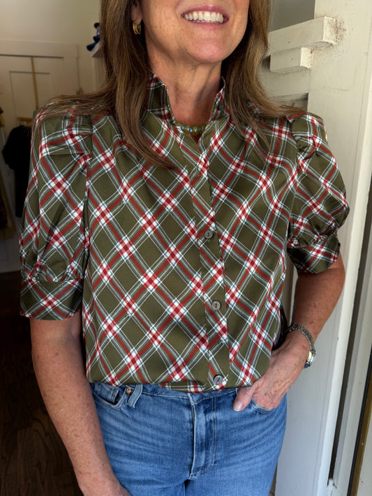 Close view of the October Blouse, a green and red plaid button front blouse, with jeans