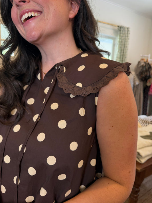 Close view of the Polka Dot Bib Mini Dress's brown fabric, cream dots and ruffle bib collar
