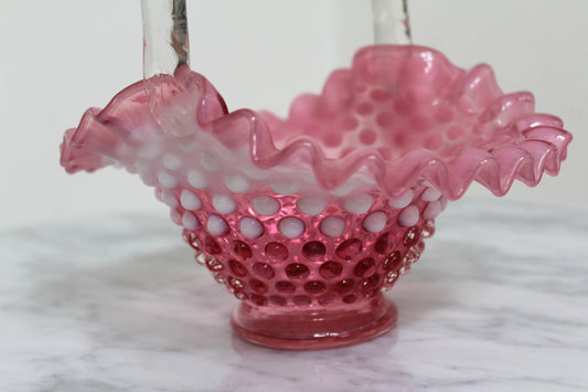 Close view of the cranberry hobnail basket's ruffled white rim